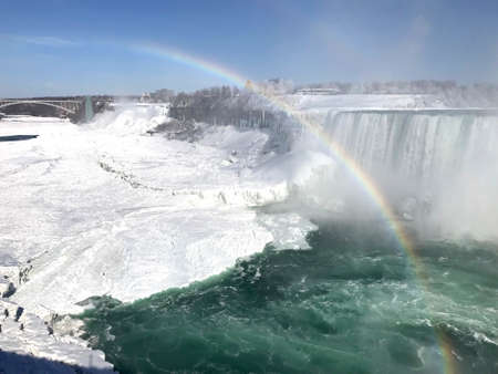 green waterfall with rainbow at Niagara cascades in winter season, Canadaの写真素材