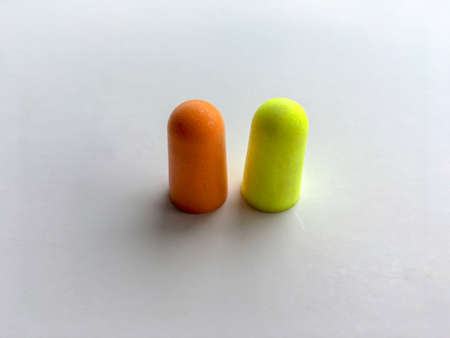 Orange and green ear plugs alignment isolated on white background