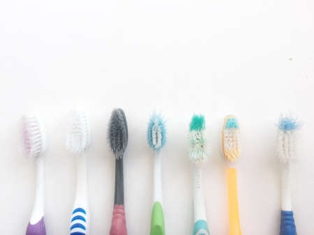 Used old colorful toothbrush on white background.