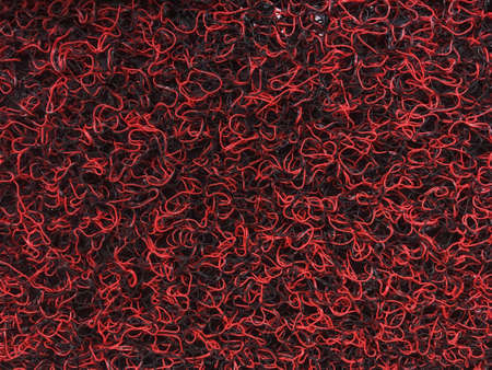 Red and black wire doodle texture close up of rough mat background.