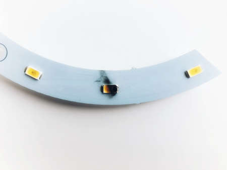 Small LED chip on curve circuit board inside lighting bulb was short and burnt. Black smoke dirty around it.の写真素材