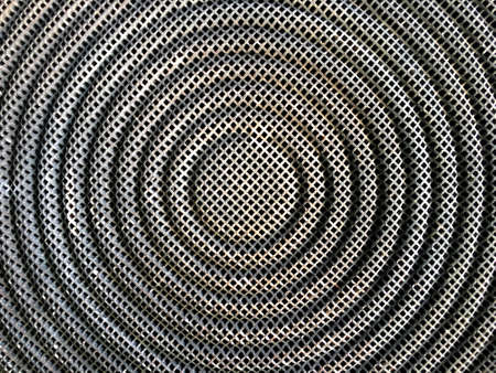 Dark Stainless steel mesh texture in circle shape background of stove top viewの写真素材