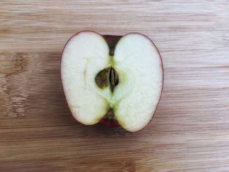 Inside freshness ripe red apple half piece slice on wooden backgroundの写真素材