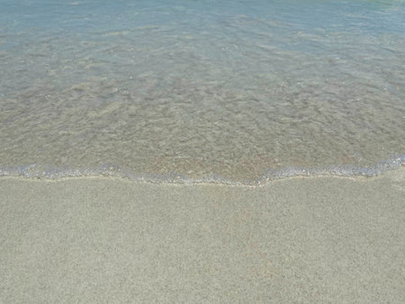 Beautiful calm blue sea and ripple on white sand at the beachの写真素材