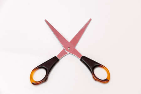 small scissors cutting brown color on a white background