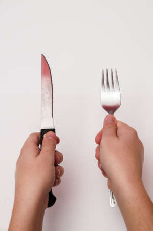 hand with fork and knife on a white backgroundの写真素材