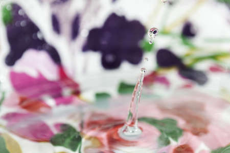 drop of water splashing on a colorful backgroundの写真素材