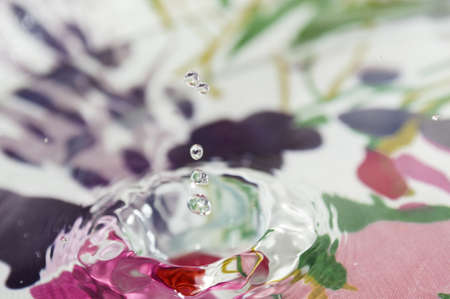 drop of water splashing on a colorful backgroundの写真素材