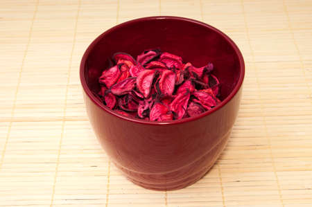 pot with pink petals on a wooden backgroundの写真素材