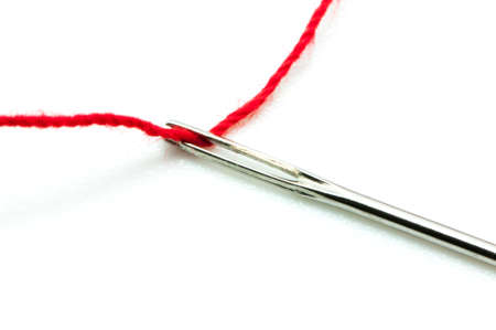 pin with red thread on a white background