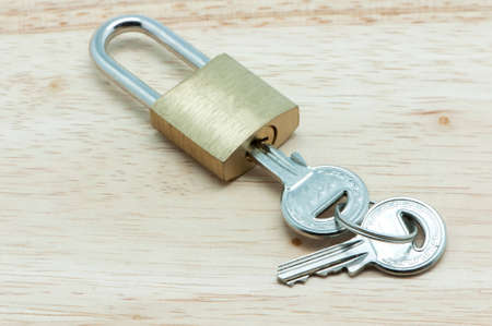 padlock with keys on a wooden
