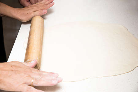 preparing pizza dough on the tableの写真素材