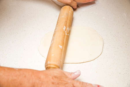 making pizza dough with rolling pinの写真素材