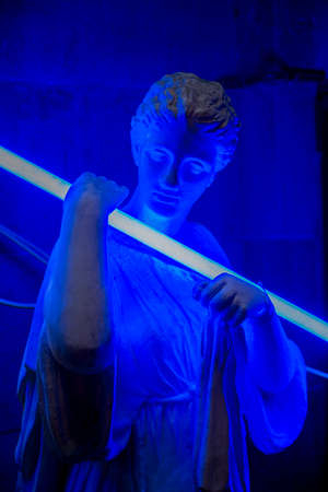 Statue catching a blue fluorescent lightの写真素材