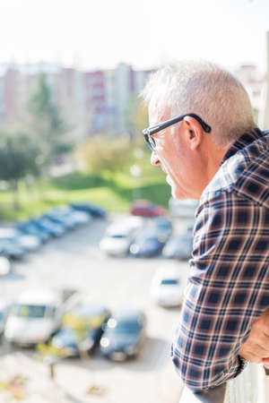 adult man looking out the balcony to the horizonの写真素材