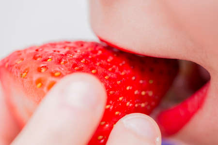 beautiful woman eating a strawberryの写真素材