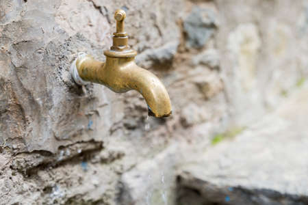 golden faucet with running waterの写真素材