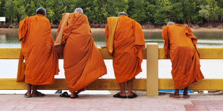 Four monks looking at the riverの写真素材