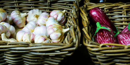 basket of clove garlic and eggplant sold in market in provence, france