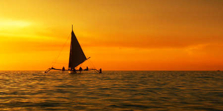 silhouette of boat on the beach during sunset in philippinesの写真素材