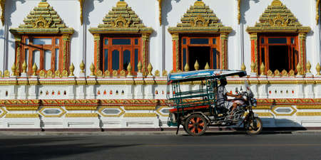 moto taxi in front of a buddhist temple in thailand