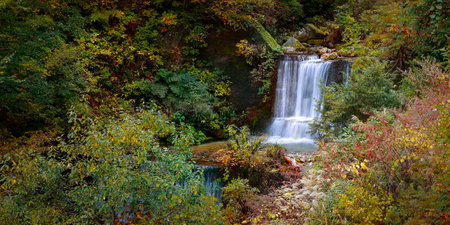 Waterfall in the autumn forest. Panoramic view of waterfall.の写真素材