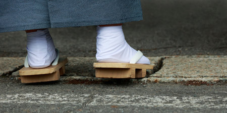 Closeup of feet dressing with geta, traditional Japanese wooden shoes