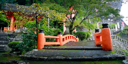 Red bridge in a Japanese garden at the entrance to the temple.の写真素材
