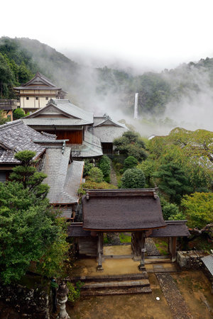 view of traditional houses and roof, in misty mountains in the center of Japanの写真素材
