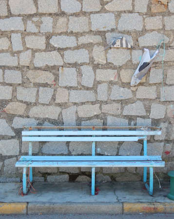 Broken bench in front of a wallの写真素材