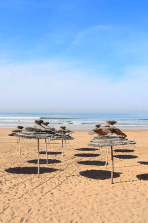 Sunshades throwing circular shades on the beachの写真素材