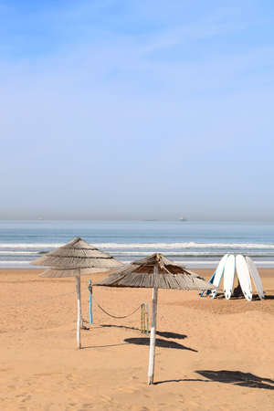 Sunshades throwing circular shadows on the deserted beachの写真素材