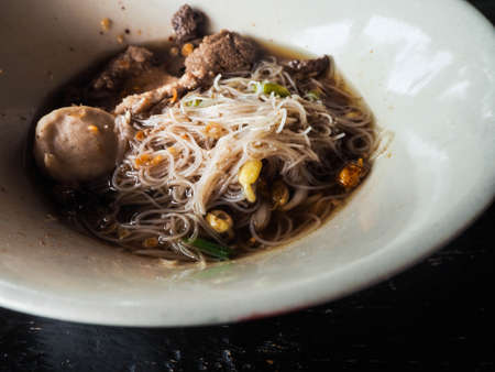 close up noodles of thicken Soup put rice Vermicelli and meatballs in bowl of white