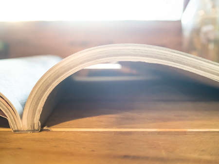 Vintage old books on wooden deck table and windows background, light shines into the windowsの写真素材