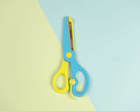 blue and yellow colourful scissors on on blue and green background. beautiful colourful picture...
