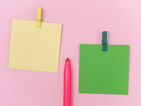 pink magic pen with green and yellow paper note and with paperclip on pink background, minimal concept and similarities differencesの写真素材