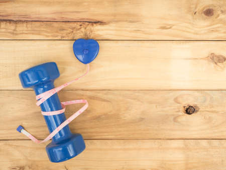 blue dumbbell and measure on wooden background with copy spaceの写真素材