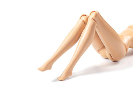 The beautiful slender legs of pretty figure girl doll doing gestures sexy isolated on white backgroundの写真素材