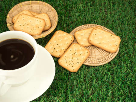 Cup of coffee and coffee beans on grass green backgroundの写真素材