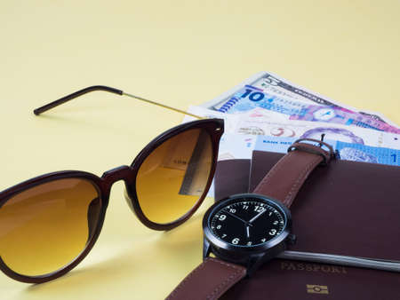 Concept go travel holiday, Vacations plan Boarding pass and passport, bank note, watch, sunglass and plan  go tourist on yellow backgroundの写真素材