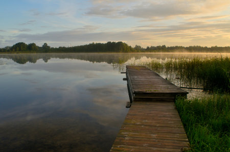 Wooden pier on the lake at sunrise in the summer, Polandの写真素材