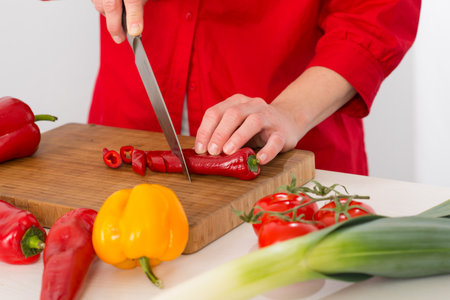 womans hand cutting vegetablesの写真素材