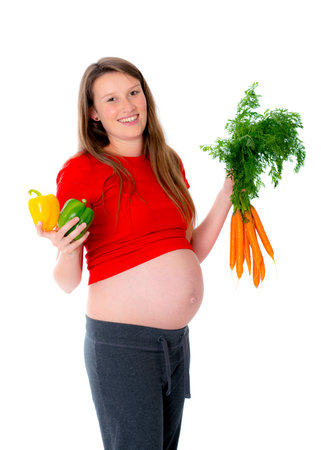 young pregnant woman is eating vegetablesの写真素材