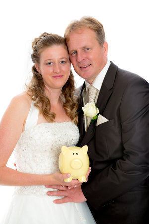 bridal couple in front of white background with piggy bankの写真素材