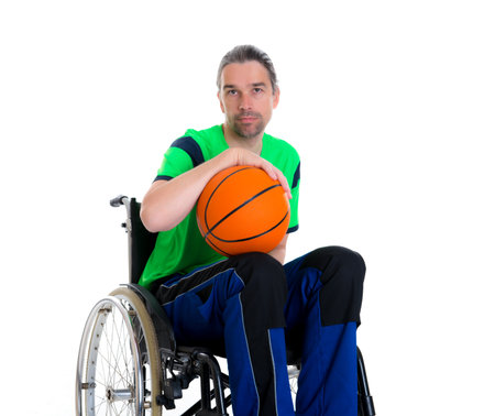 young disabled man in a wheelchair is doing sport with ballの写真素材