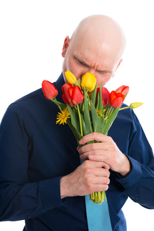 young man with bunch of tulips in front of white backgroundの写真素材
