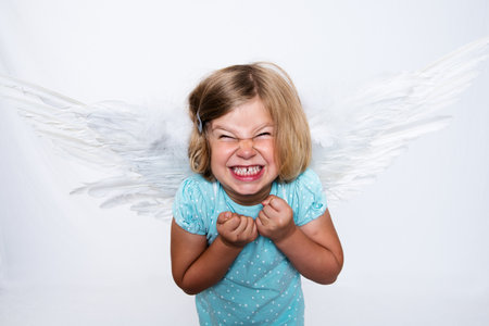 wild blond girl with angel- wings in front of white backgroundの写真素材