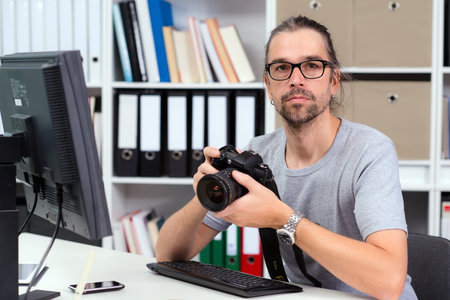 creative man with camera is working in his officeの写真素材