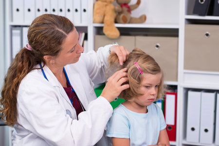 female pediatrician in white lab coat examined little girl