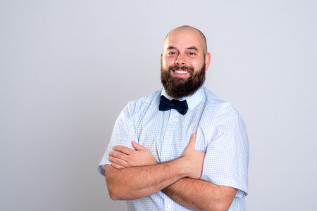 young smiling and bearded man in blue shirt and bow tieの写真素材